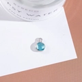 Macro shot of a round sky blue crystal pendant with silver bezel setting on white card - Outer Size 6.5x10mm / Lake Blue