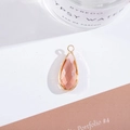 Close-up of pink crystal teardrop pendant with gold-plated metal border for DIY jewelry - Outer Size 11x25mm / Rose Red