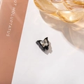 Detailansicht einer glänzend schwarzen Schmetterling-Haarklammer mit Kristallstein - Schwarze Basis Weißer Schmetterling