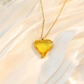 Detailaufnahme eines herzförmigen gelben Kristallanhängers an einer goldenen Kette - Leuchtgelb