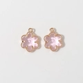Detailed macro of pink six-petal flower pendants with gold milgrain frames for jewelry DIY - Pink