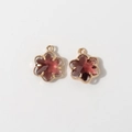 Detailed view of 12mm gold-plated flower pendants with deep red faceted crystal stones - Purple