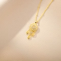 Close-up of golden dreamcatcher pendant with leaf charms and sparkling crystal accents - Gold