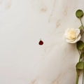 Detail of a red teardrop zircon pendant with gold rim and elegant white rose on marble - Red Water Drop Pendant (Gold Edge) / Red