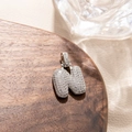 Detailed macro view of silver N-letter pendant with pavé-set shimmering zircon stones - Letter N