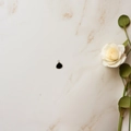 Detail of a minimalist black teardrop pendant with gold plating on a marble background - Black
