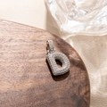 Detailed macro view of silver letter D pendant with micro-pave cubic zirconia stones - Letter D