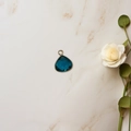 Teardrop pendant with dark blue faceted gemstone and golden metal frame on marble - Dark Blue