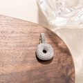 Macro detail of high-quality pavé cubic zirconia on silver-tone circular donut pendant - Letter O