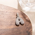 Macro detail of silver letter A pendant featuring micro-pave cubic zirconia stones - Letter A