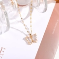 Detail eines goldenen Schmetterlingsanhängers mit klaren Flügeln und Zirkonia-Besatz - 7*15mm Schmetterling / Weiß