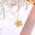 Detailansicht einer goldenen Titan-Halskette mit einem gelben Schmetterlingsanhänger - 7*15mm Schmetterling / Gold