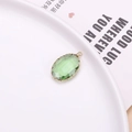 Pendente ovale in vetro verde smeraldo sfaccettato con bordo a petalo placcato oro - verde chiaro