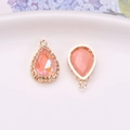 Peach crystal teardrop charm with gold bird nest casing and filigree back details - Pink