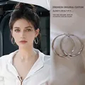 Silberne gedrehte Creolen für Damen im minimalistischen Design an einem Modell - Gedrehte Creolen / Silber