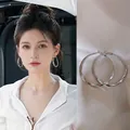 Silberne gedrehte Creolen für Damen im minimalistischen Design an einem Modell - Gedrehte Creolen / Silber