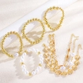 Detail of gold bead bracelets with pearls and shell pendants on textured surface - Ocean Combo Multi-Layer Artificial Pearl Style / KC Gold (8009)