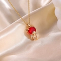 Dettaglio del ciondolo a forma di orso dorato con pietra rossa su seta color champagne - Ciondolo Orso Rosso Con Collana Catena O