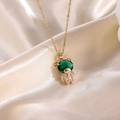 Dettaglio macro di un ciondolo astronauta dorato con pietra verde e zirconi incastonati - Ciondolo Orso Verde Con Collana Catena O