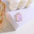 Detail van roze kristallen rechthoekige hanger met vergulde klauwzetting op witte kubus - Roze Opaal