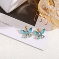 Detailed close-up of blue crystal butterfly charms with gold plating for jewelry making - Lake Blue