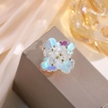 Macro detail of an iridescent pearl flower hair accessory on a grey jewelry box - Four-Petal Flower