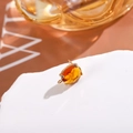 Macro shot of gold-plated oval amber crystal stud earring with classic S925 silver needle - Reddish Brown