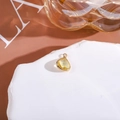 Close-up of a teardrop yellow crystal pendant with gold frame on a stone tray - Light Yellow