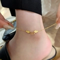 Golden titanium steel anklet with fish pendants and beads on a woman's ankle - Double Fish Round Bead Anklet (J725)