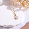 Macro shot of gold-plated pear opal pendant with sparkling zircon accents and heart clasp - White Opal