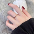 Close-up of a rose gold engraved band ring worn on the finger in a lifestyle setting - Size 5 / Letter Style (358) / Rose Gold