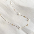 Detailed macro view of minimalist pearl necklace with gold chain on white fabric background - Artificial Pearl Gypsophila Necklace (86204) / Gold