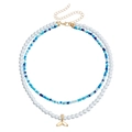 Double-layer necklace with blue beads, white pearls, and a golden whale tail pendant - Fish Tail Pendant