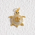 Dettaglio di un ciondolo a tartaruga dorata con zirconi e motivo di moneta antica - Ciondolo a Tartaruga con Motivo a Moneta e Strass (DYL-4627)