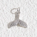 Dettaglio macro del ciondolo a coda di balena con cristalli pavé su fondo bianco strutturato - Ciondolo a Coda di Balena Look Diamante (DYL-4628)