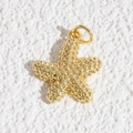 Dettaglio macro di un ciondolo a stella marina dorata con texture di perline e anello - Ciondolo a Stella Marina Texturizzato a Grana Perlinata (DYL-4639)