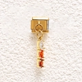 Macro detail of a gold stainless steel modular link charm with triple oval gemstones - Red-Orange Triple Oval Stone (MKDZ-839)