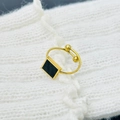 Detalle macro de anillo ajustable de titanio dorado con incrustación negra y perlas - Abierto Ajustable / Cuadrado Negro