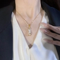 Elegant gold titanium necklace featuring a white faux jade bamboo joint pendant on model - White Style (85070)
