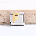Macro view of gold letter F charm for Italian modular bracelet in polished stainless steel - Letter F