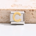 Macro shot of Italian charm bracelet link with gold letter C on silver stainless steel - Letter C