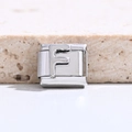 Makro-Detail des silbernen Edelstahl-Charm-Links mit geprägtem Buchstaben F für Armbänder - Buchstabe F