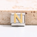Macro view of gold letter N Italian charm link made of polished stainless steel - Letter N