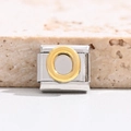 Macro shot of Italian charm link featuring a golden letter O on a stainless steel base - Letter O