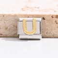 Macro shot of Italian charm bracelet link with gold-plated letter U on stainless steel base - Letter U