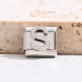 Makro-Detail eines italienischen Modul-Charms mit poliertem silbernem Buchstaben S aus Edelstahl - Buchstabe S