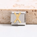 Close-up of a stainless steel Italian charm bracelet link with a golden letter X - Letter X