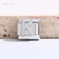 Makroaufnahme von silbernem italienischem Modul-Charm aus Edelstahl mit 3D-Buchstabe K - Buchstabe K
