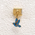 Macro view of a gold stainless steel Italian charm featuring a blue enamel bird pendant - Blue Bird Style (GMKDZ-691)