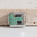 Macro shot of silver stainless steel charm with green enamel and sarcastic text - Me? Sarcastic? Never (MK-1507)